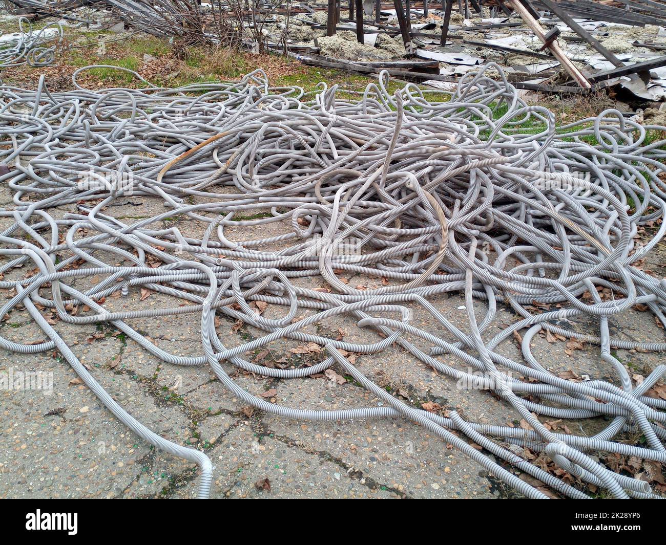 Corrugated pipes for electrical wiring lie in heap on the ground. Stock Photo