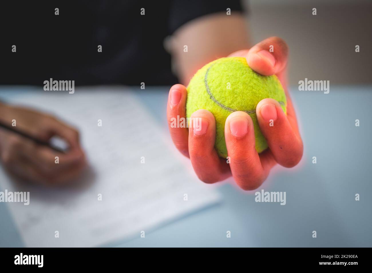The man massages his finger by tennis balls. Office syndrome concept. Pain symptom area is shown with red color. Close up shot. Stock Photo