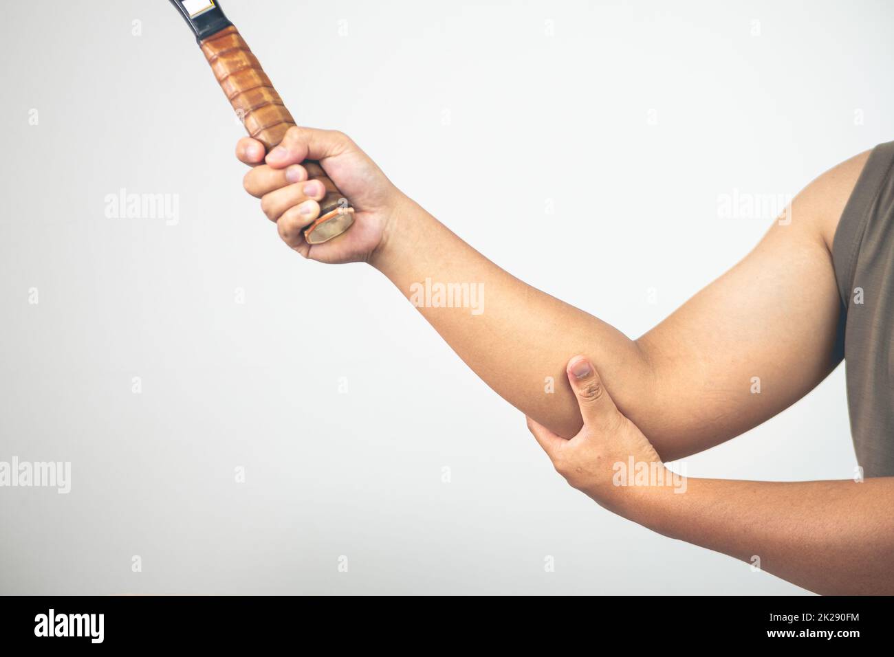 Tennis elbow injury concept. The man holds racket. Healthcare knowledge. Medium close up shot with copy space. Stock Photo