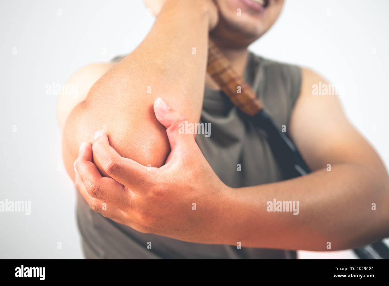 Tennis elbow injury concept. The man holds racket. Symptom area is shown with red color. Healthcare knowledge. Medium close up shot. Stock Photo