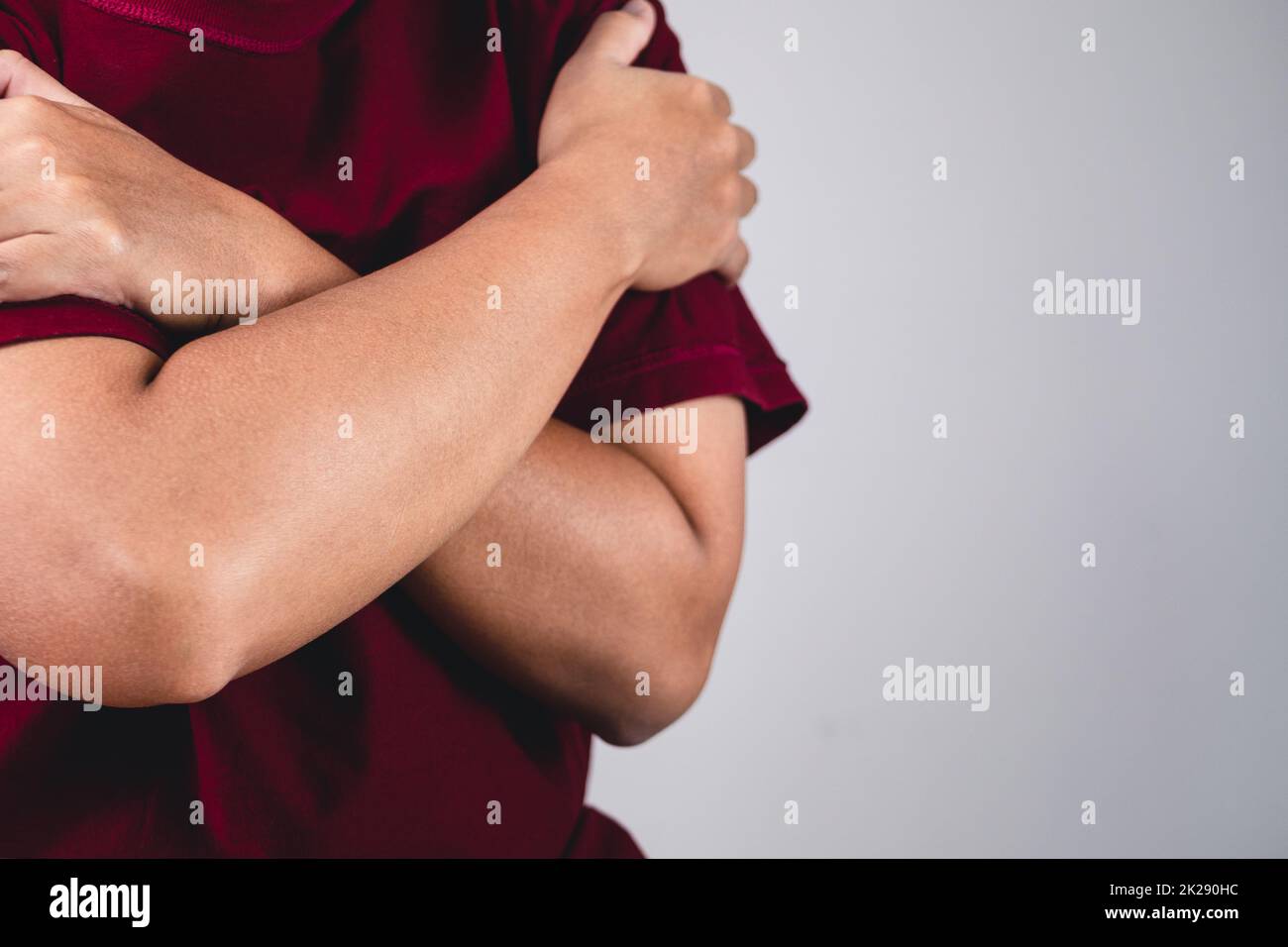 Sign of self love. Hug youself and Positive thinking. The man with red shirt in medium close up shot. Copy space for messages, words and texts. Stock Photo