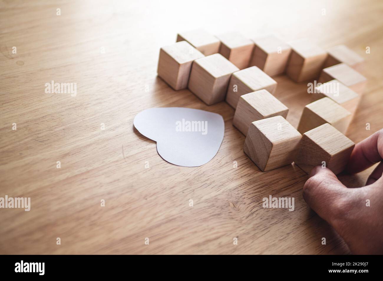 Love connection concept. Someone assembles wood blocks to  be heart shape. Stock Photo