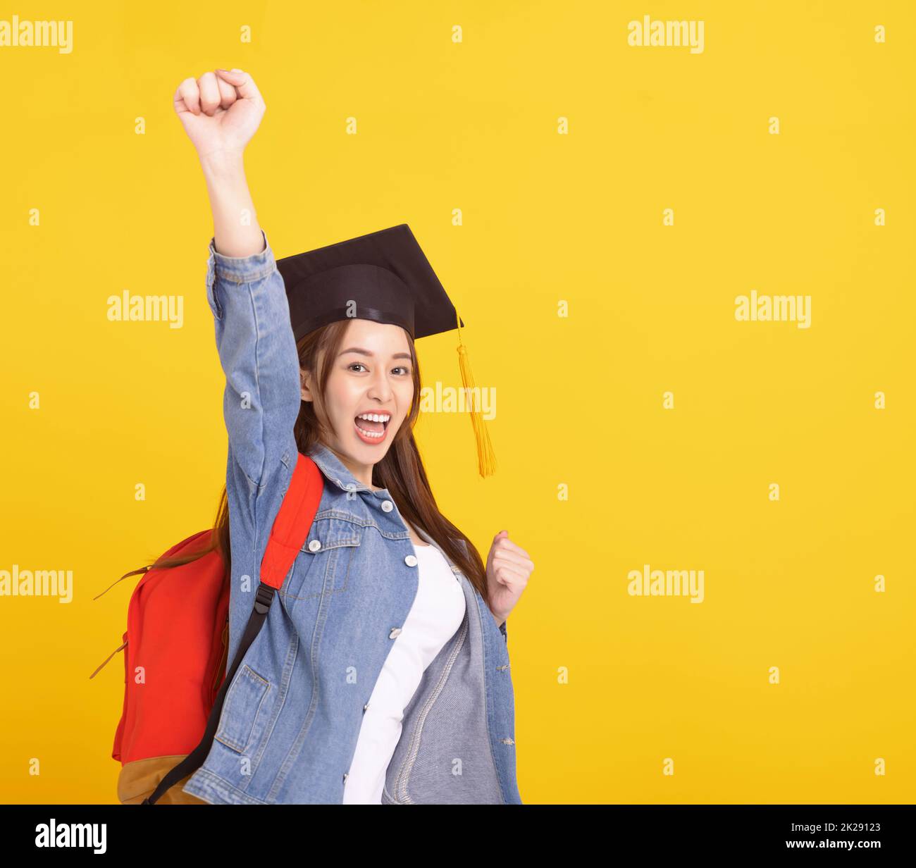Happy Asian girl college student in Graduation cap  with success gesture Stock Photo