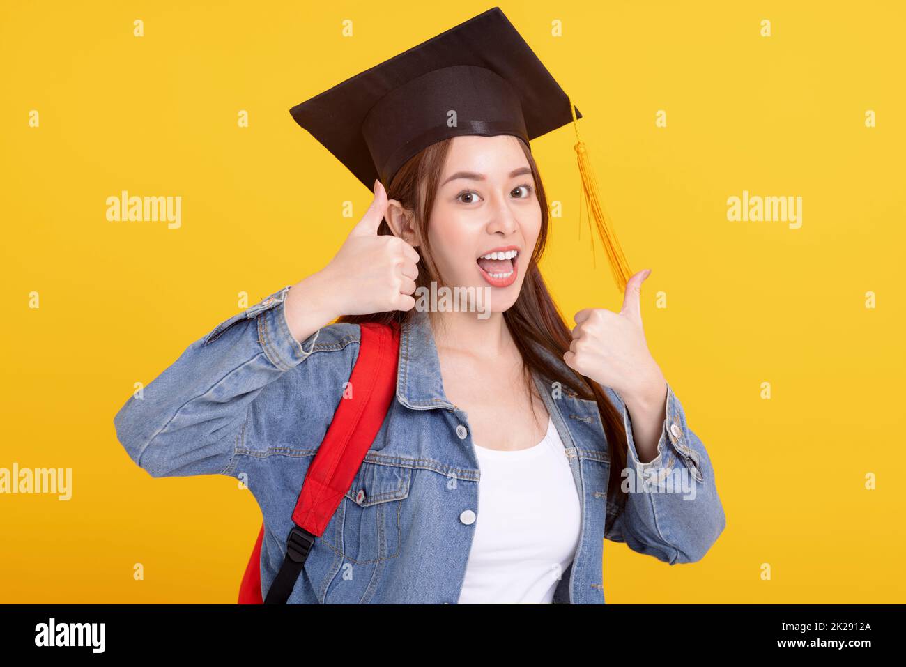 Happy Asian girl college student in Graduation cap  with thumbs up  gesture Stock Photo