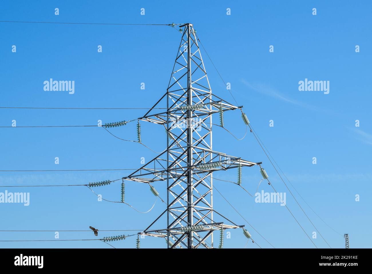 Supports high-voltage power lines against the blue sky Stock Photo - Alamy