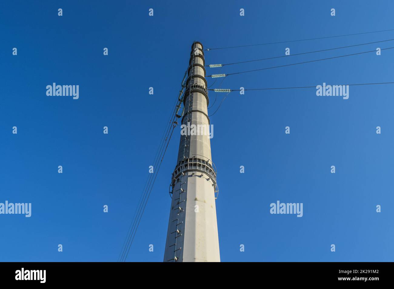 Supports high-voltage power lines against the blue sky Stock Photo - Alamy