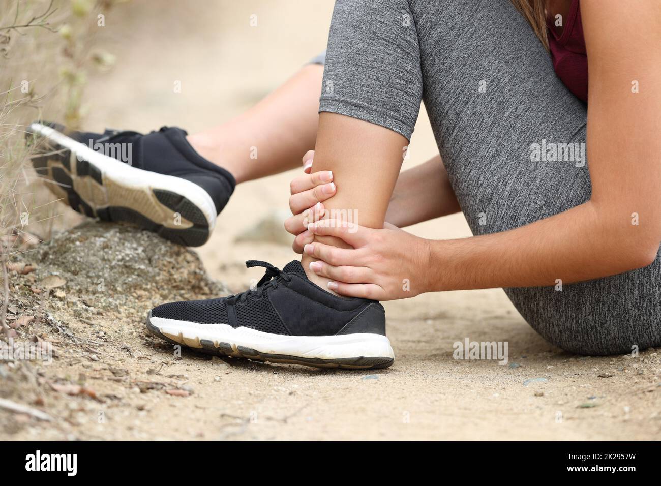 Runner grabbing sprained ankle in the mountain Stock Photo Alamy
