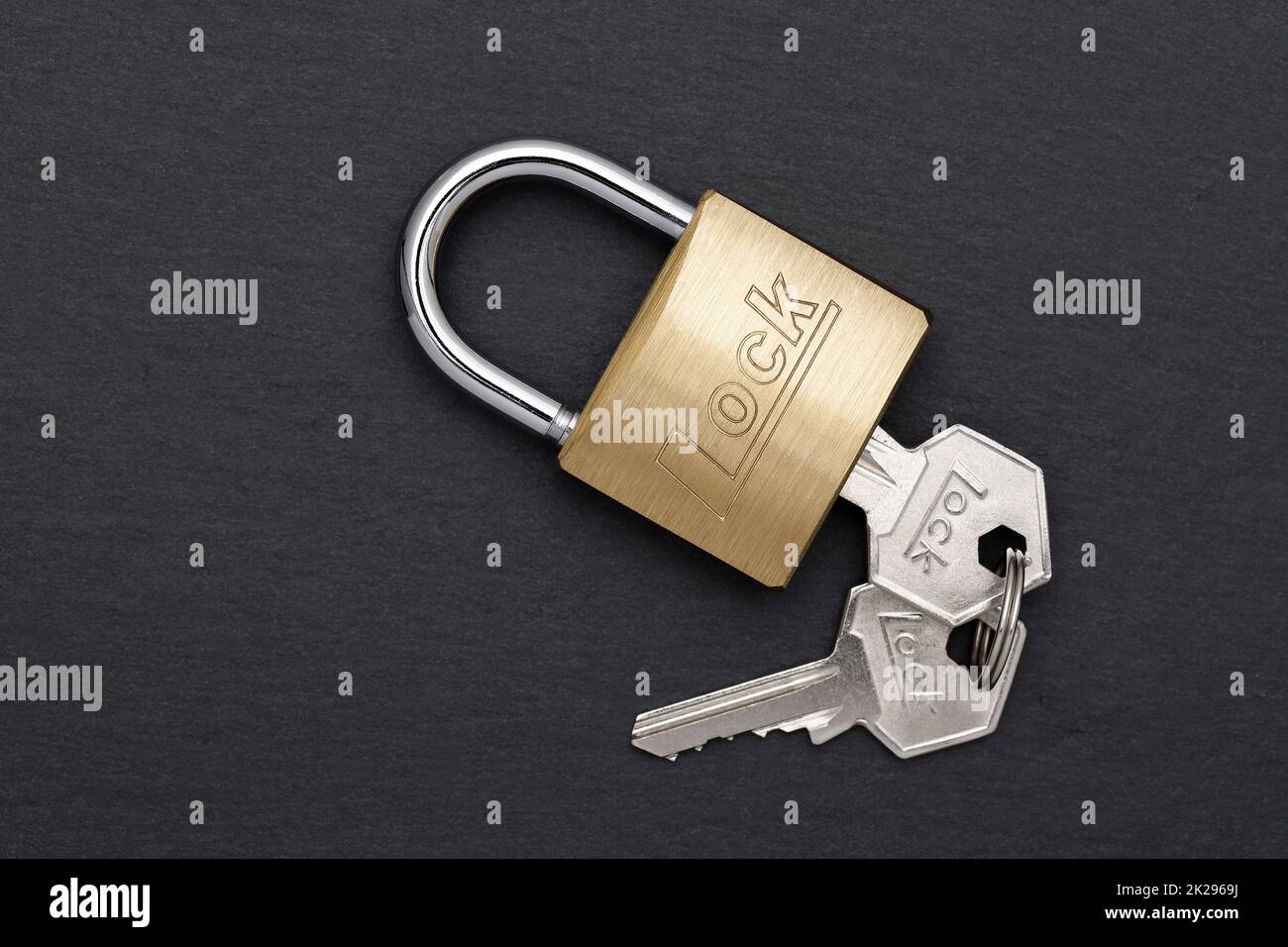 Steel padlock with key on a black background Stock Photo - Alamy
