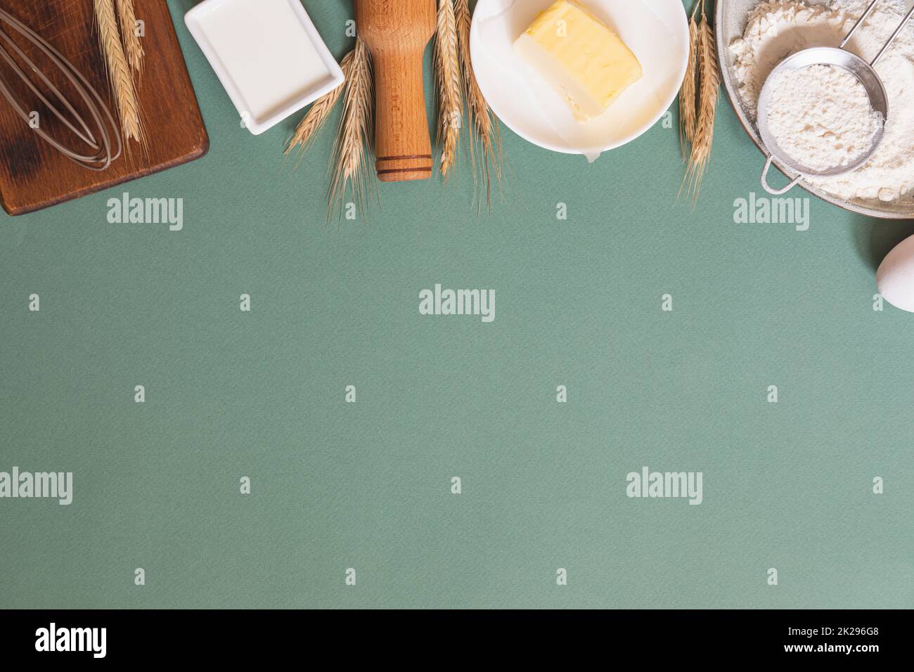Frame of food ingredients for baking on a green pastel background ...