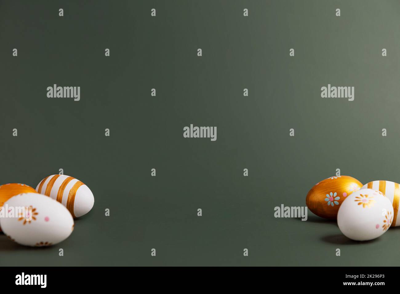 Easter holiday conceptual background. Painted golden Easter eggs on green table Stock Photo