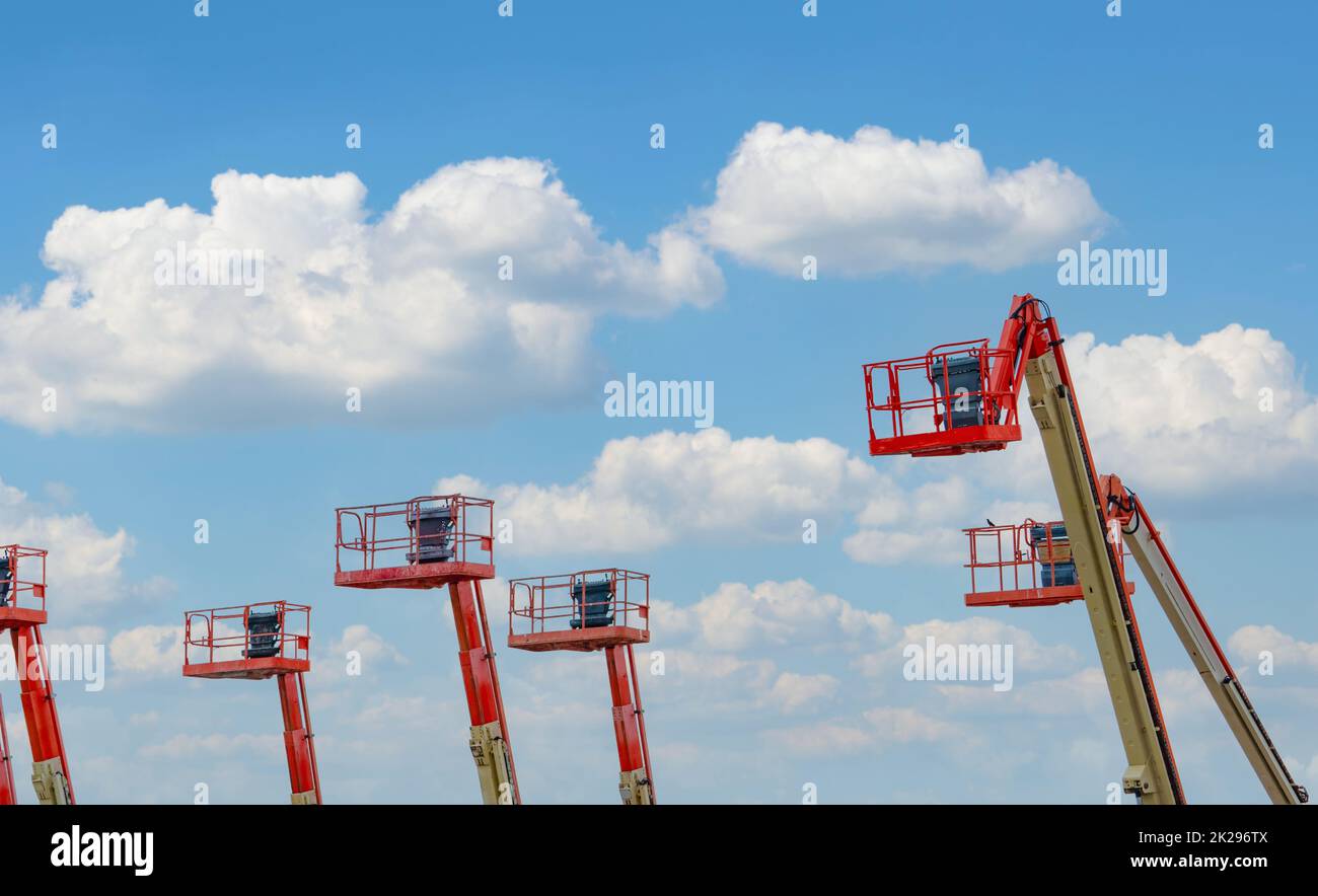Articulated boom lift. Aerial platform lift. Telescopic boom lift against the sky. Mobile construction crane for rent and sale. Maintenance and repair hydraulic boom lift service. Crane dealership. Stock Photo