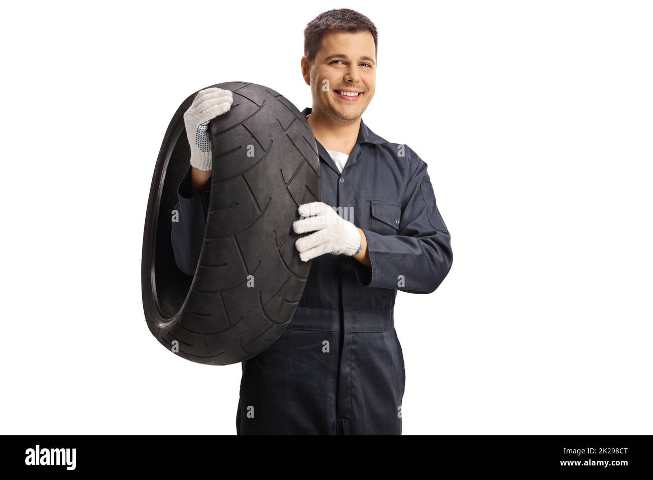 Auto mechanic holding a motorcycle tire isolated on white background Stock Photo