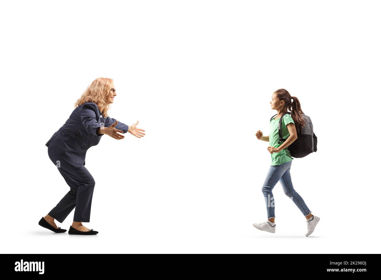 Schoolgirl holding a book and running to hug her mother isolated on white background Stock Photo