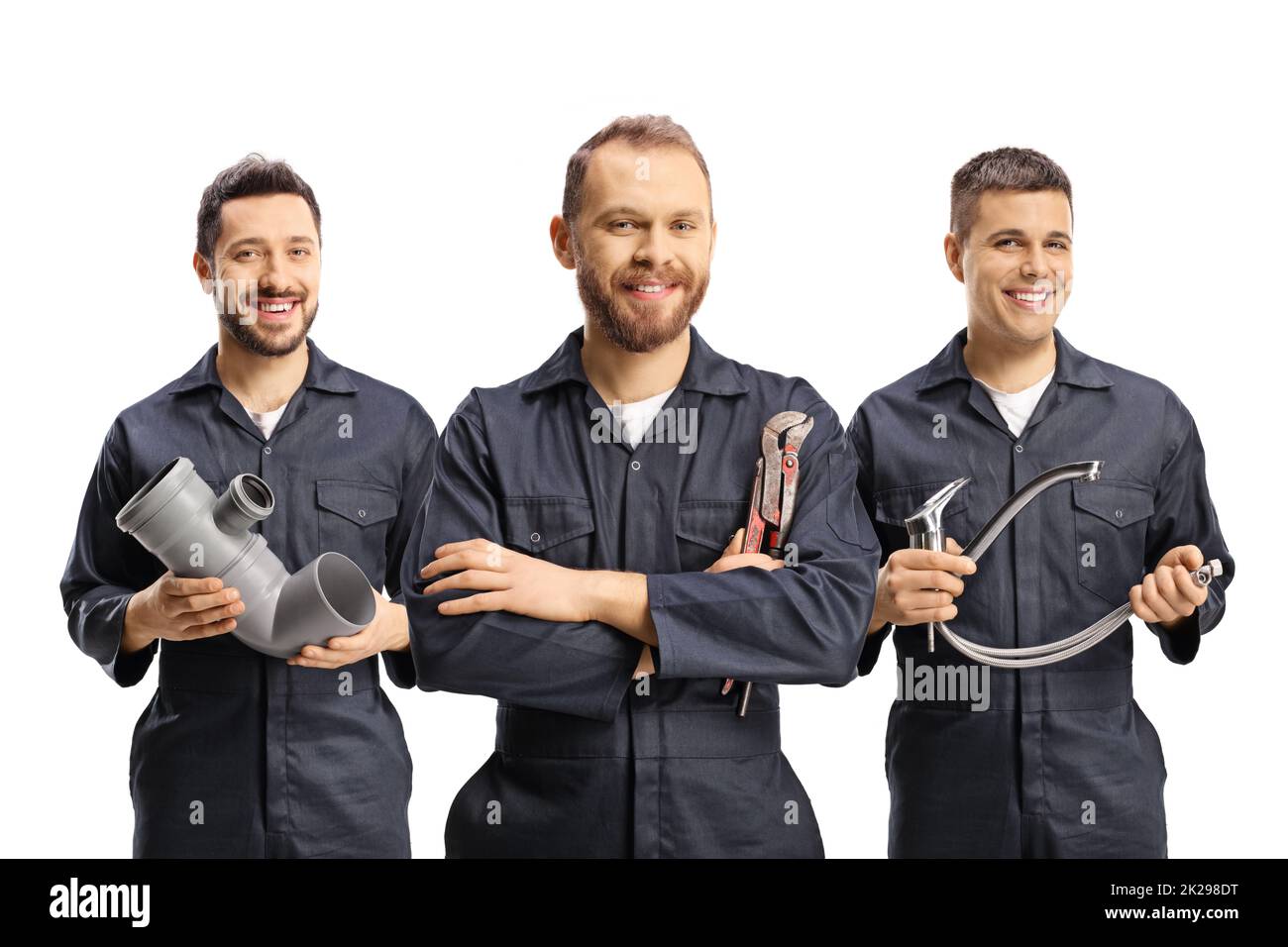 Team of plumbers holding plumbing equipment isolated on white