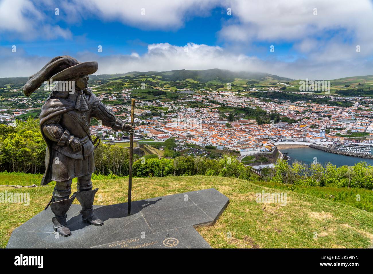 Statue of Afonso VI Second King of Portugal on Monte Brasil with a view of the historic city centre, public beach called the Praia de Angra do Heroismo below, in Angra do Heroismo, Terceira Island, Azores, Portugal. Stock Photo