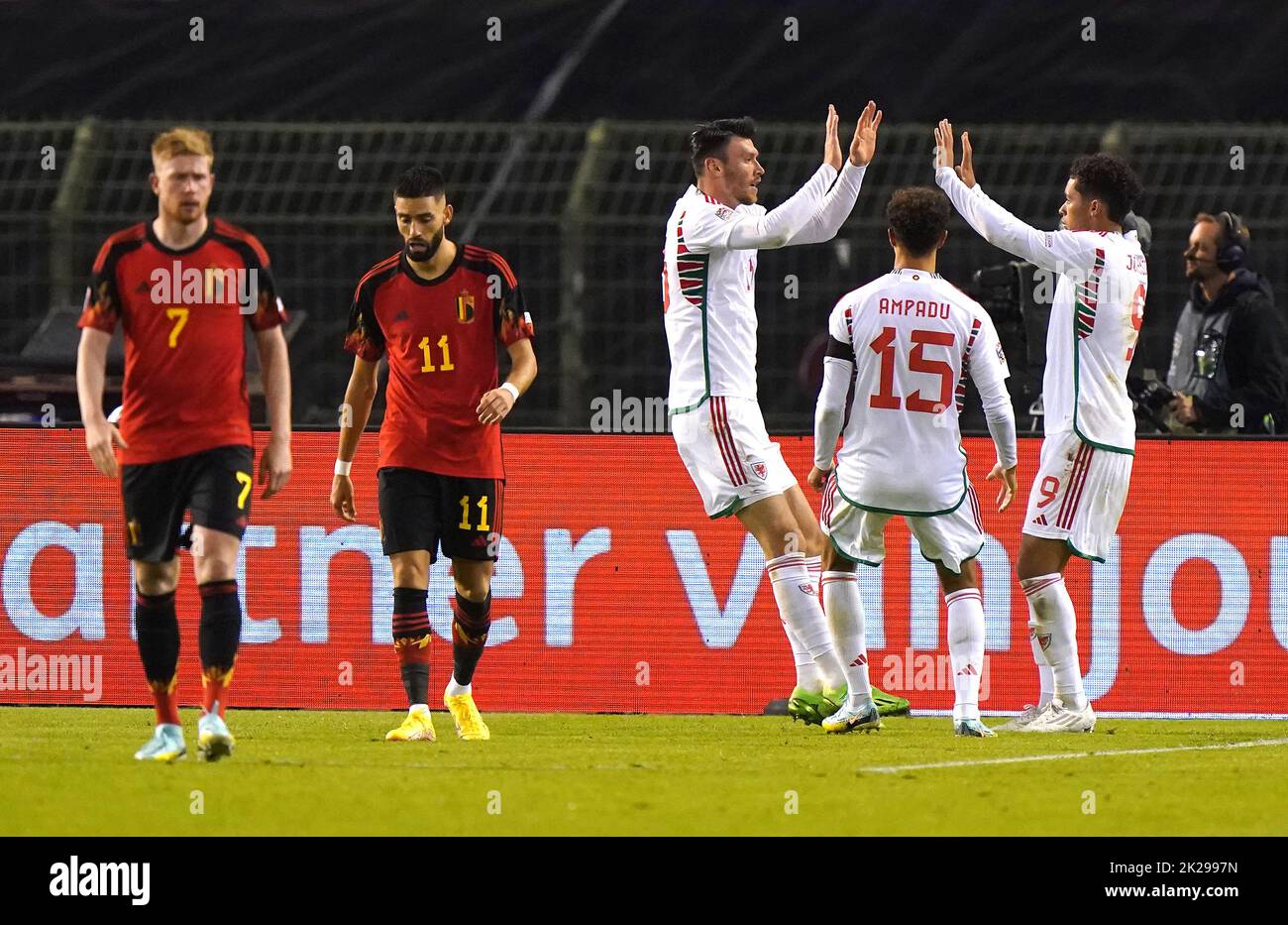 Wales' Kieffer Moore (centre) celebrates scoring their side's first goal of the game with team-mates Ethan Ampadu and Brennan Johnson (right) as Belgium's Kevin De Bruyne (left) and Yannick Carrasco looks dejected during the UEFA Nations League Group D Match at King Baudouin Stadium, Brussels. Picture date: Thursday September 22, 2022. Stock Photo