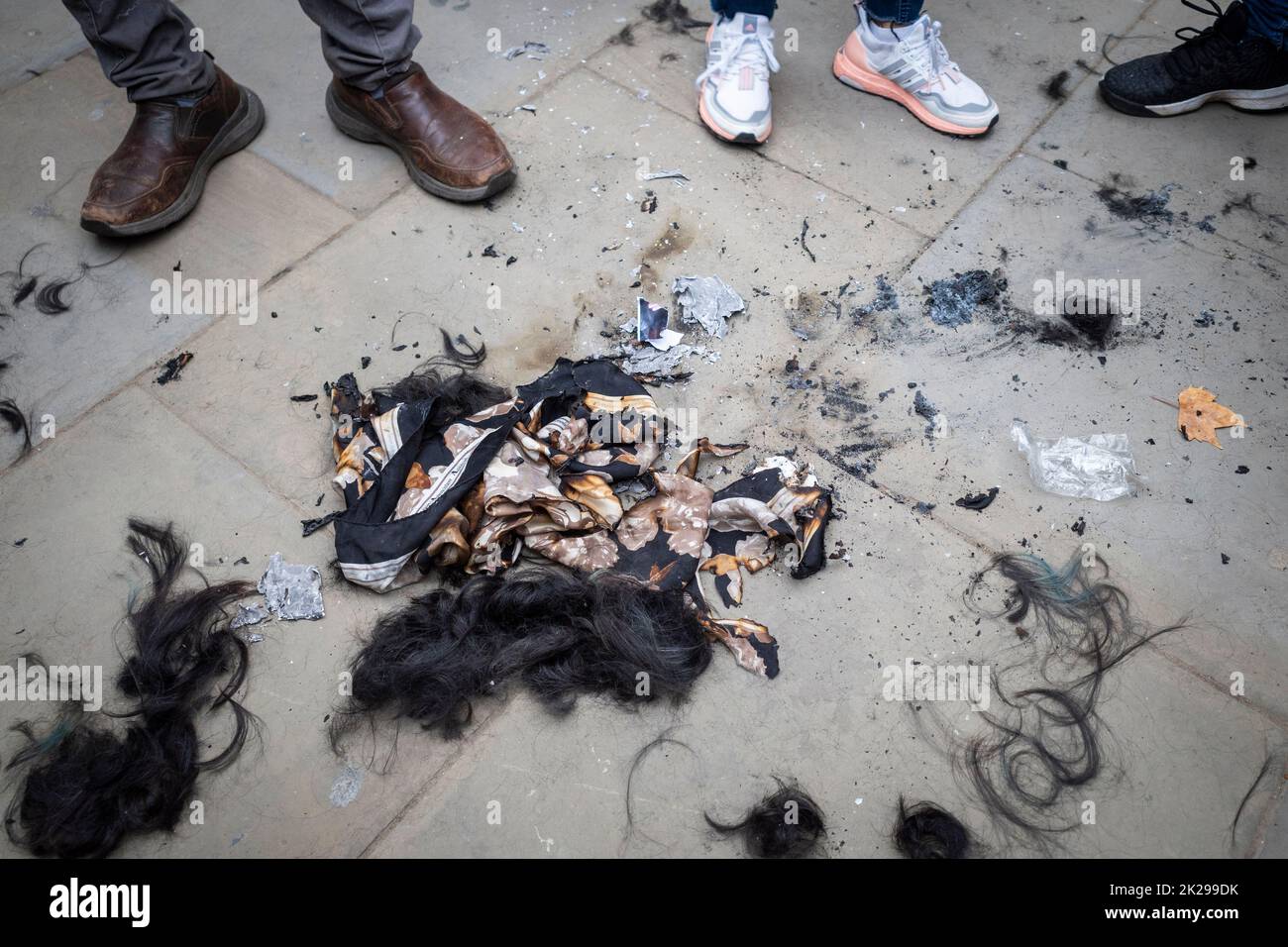 London, UK.  22 September 2022.  A hijab burned next to hair from shaved heads during a protest in Parliament Square by Iranians living in London reacting to news of the death, on 16 September of Mahsa Amini, a 22-year-old Kurdish woman, who died in police custody in Tehran.  Allegedly, she had been detained by Iran’s morality police for wearing a hijab headscarf in an “improper” way.  Protests are taking place in Iran and the access to the internet and social media is now being restricted. Credit: Stephen Chung / Alamy Live News Stock Photo