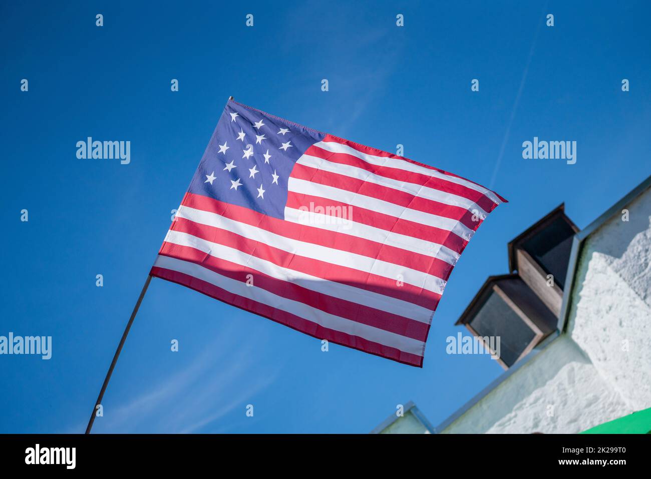 flag flies against a blue white sky on a summer day in Bavaria Stock Photo
