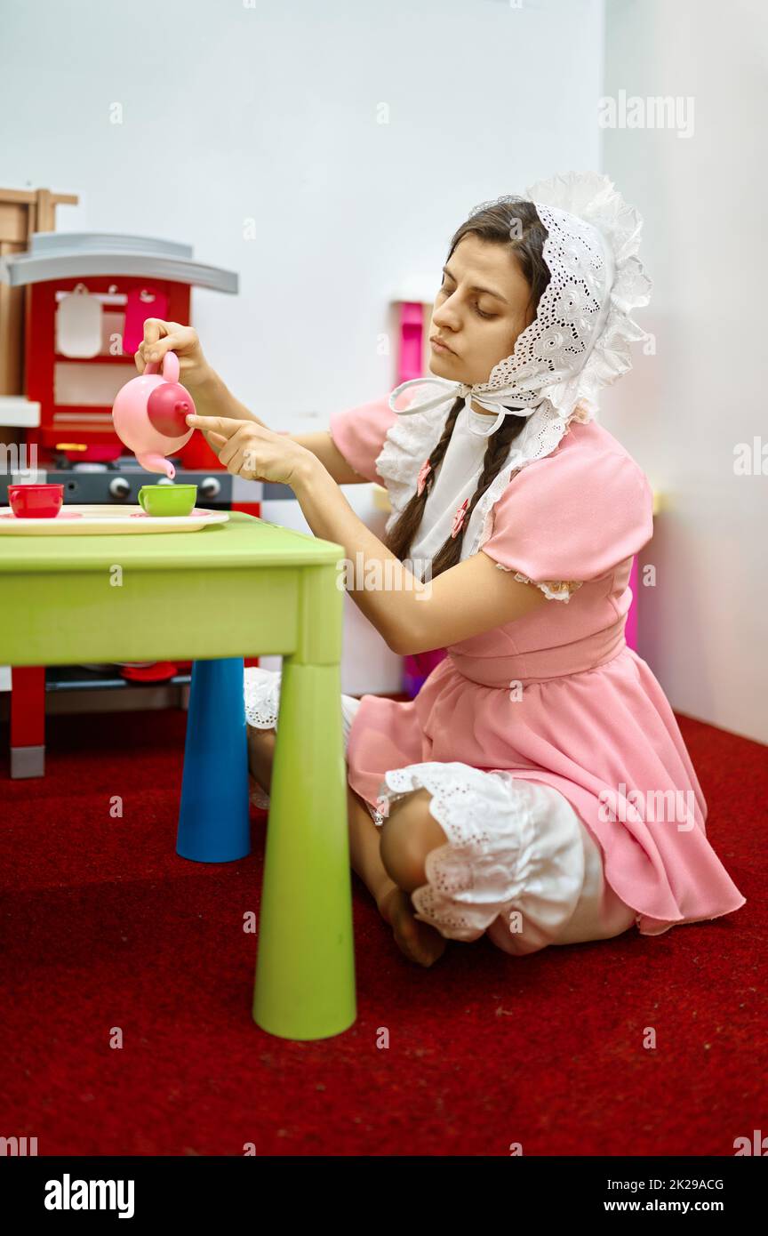 Funny woman like baby playing tea party Stock Photo