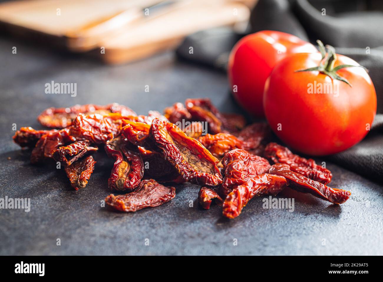 Sun dried tomatoes on black table. Stock Photo