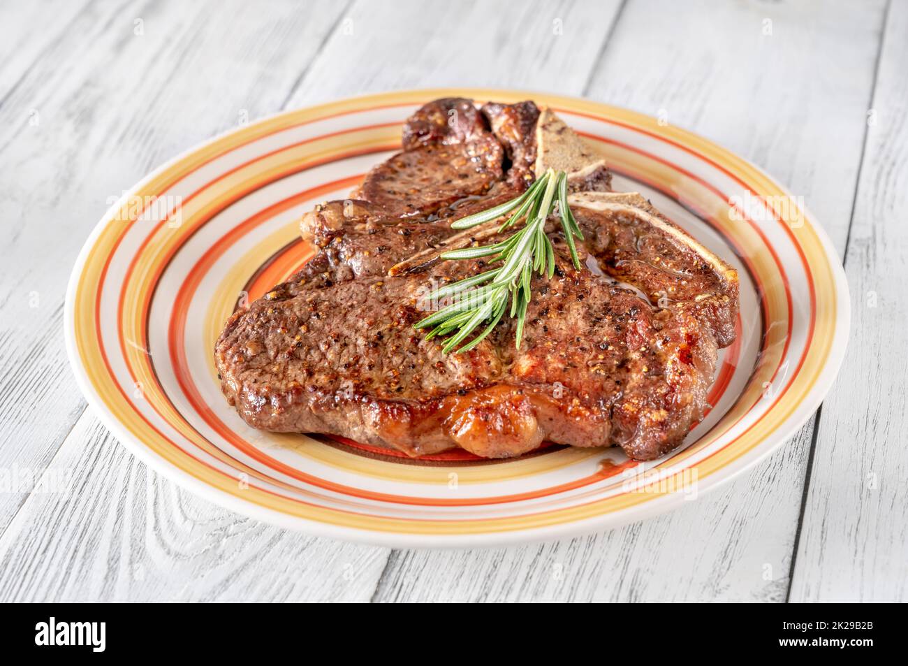 Pan-fried T-bone steak with fresh rosemary Stock Photo