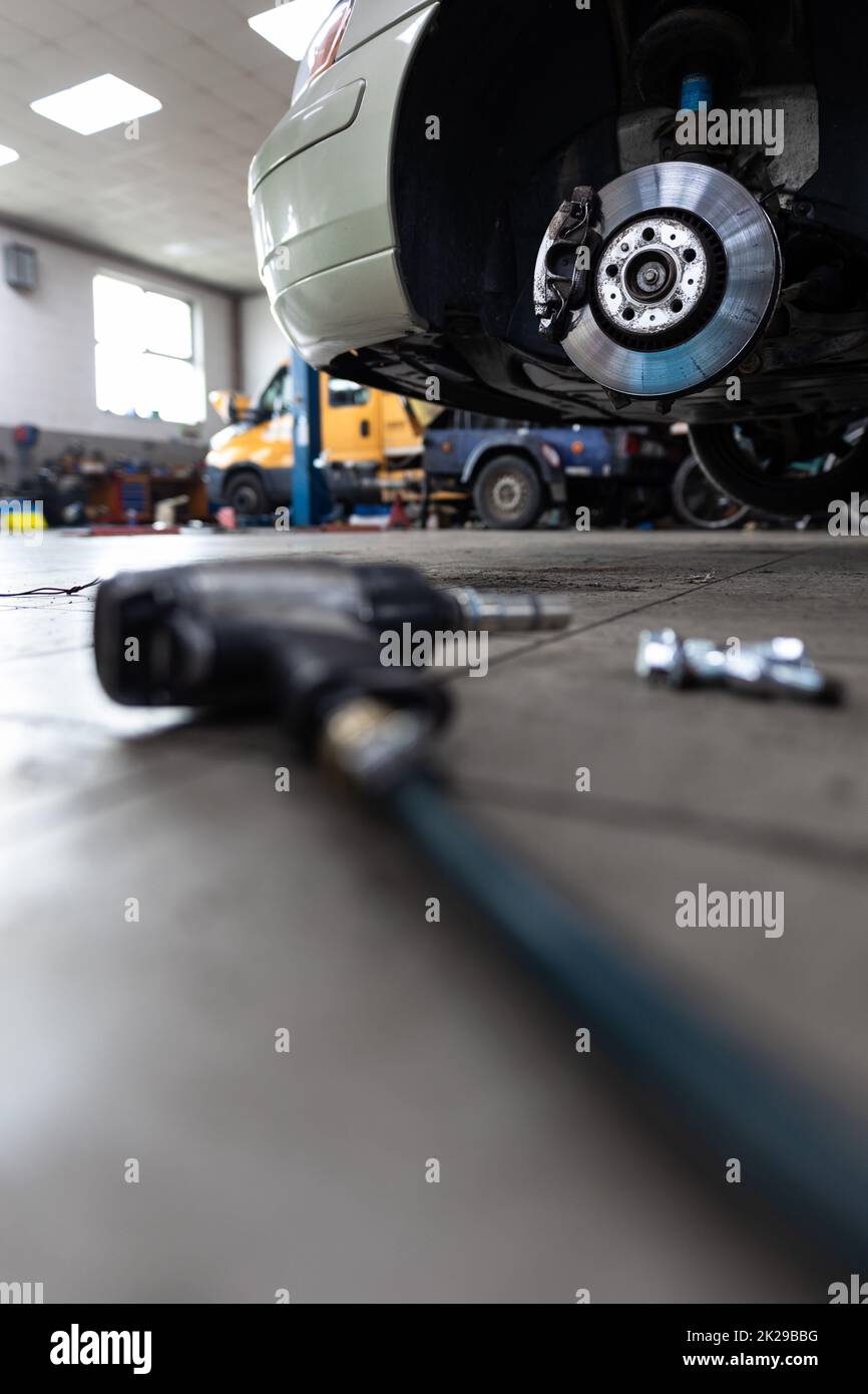 Car in a garage for maintenance, oil/tyre change (shallow DOF  color toned image) Stock Photo