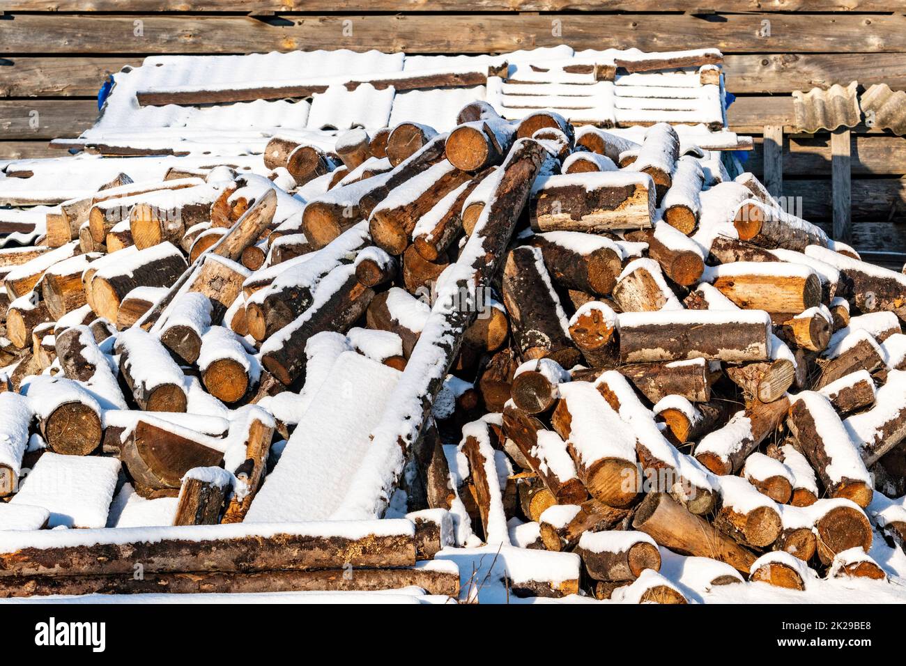 Recently chopped firewood piled up and covered in snow Stock Photo