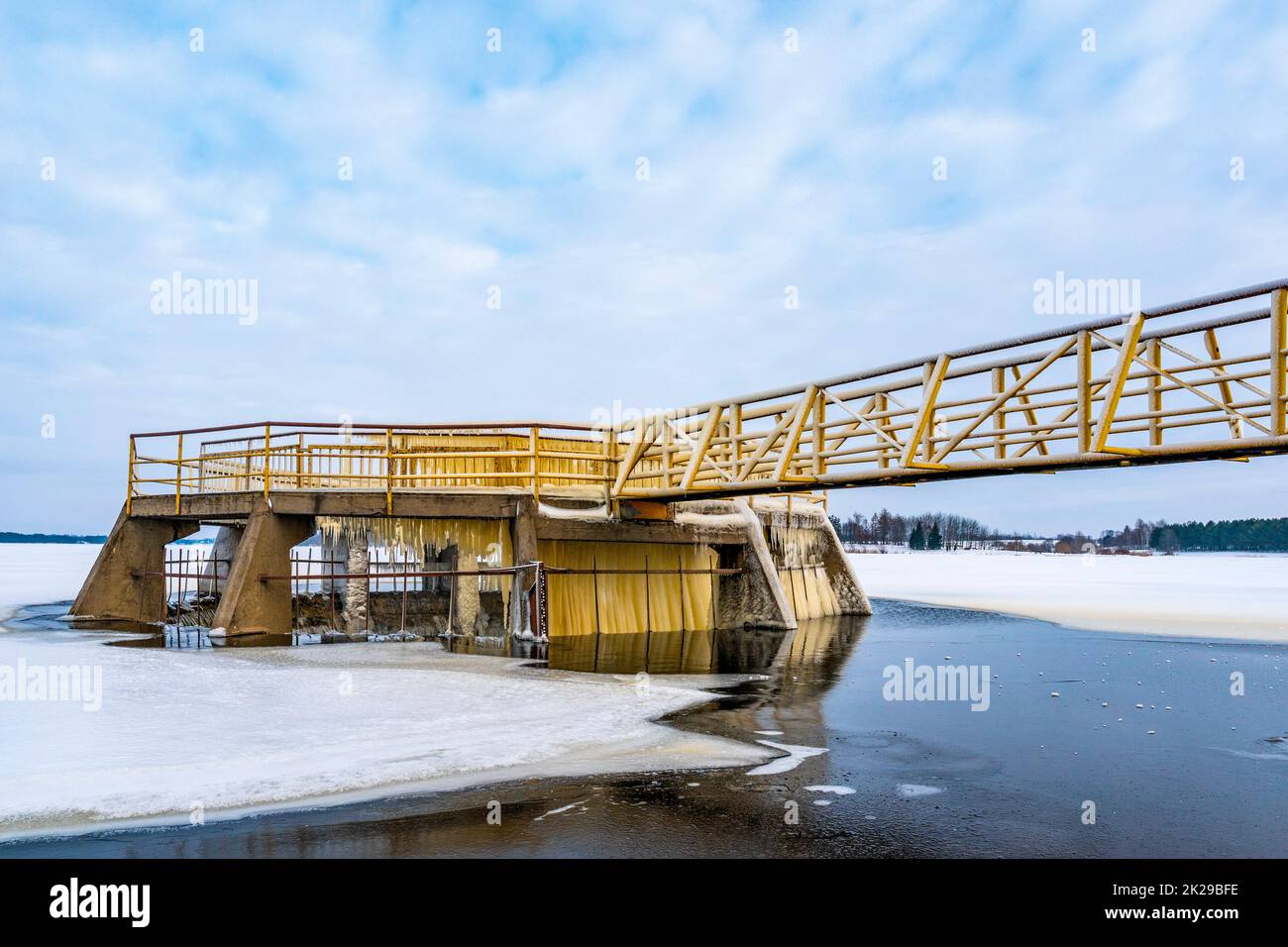 Yellow metallic bridge construction with viewing platform, concrete  spillway Stock Photo