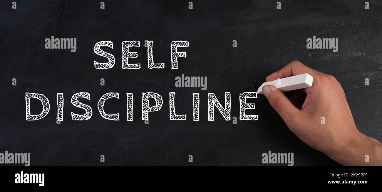 Self discipline is standing on a chalkboard, improvement by education, willpower to reach goals Stock Photo