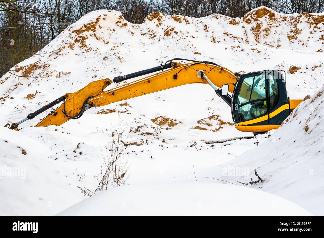 Excavator machine working at sand quarry during winter time Stock Photo