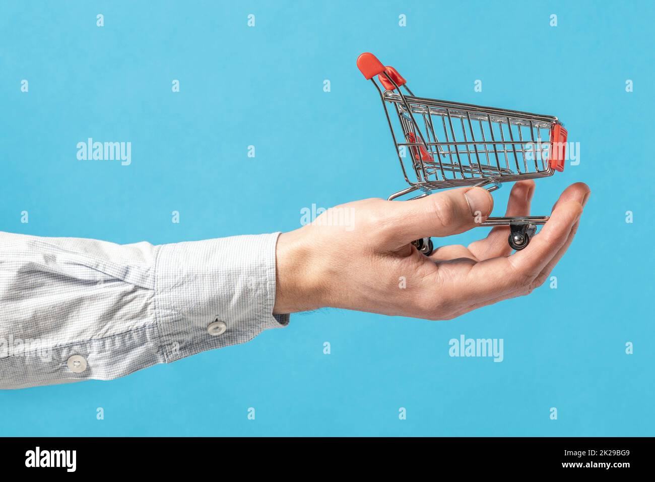 Toy shopping cart in a businessman hand Stock Photo