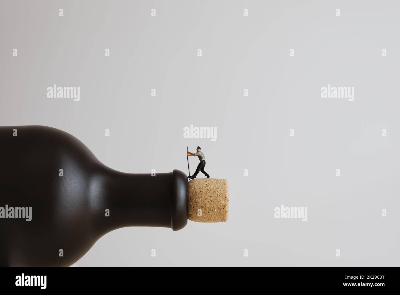 Closeup of a miniature worker opening a bottle Stock Photo