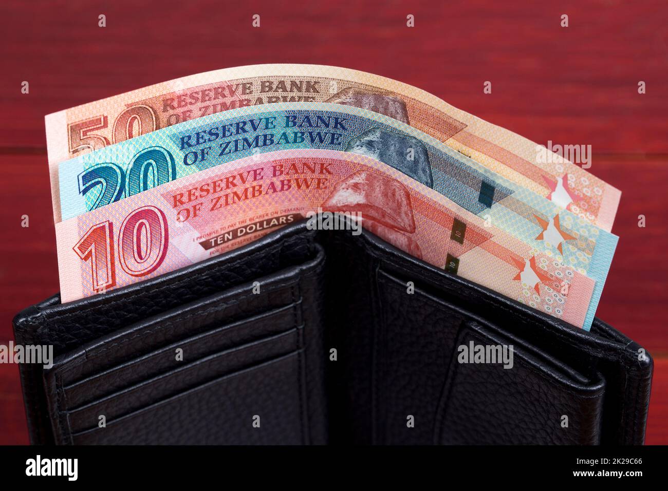 Zimbabwean banknotes in the black wallet. Stock Photo
