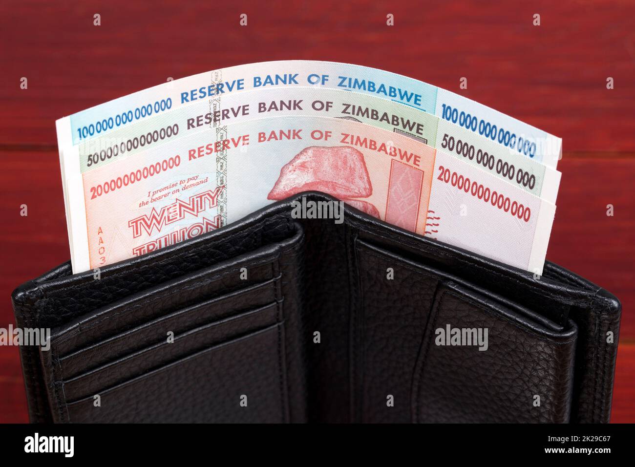 Old Zimbabwean banknotes in the black wallet. Stock Photo