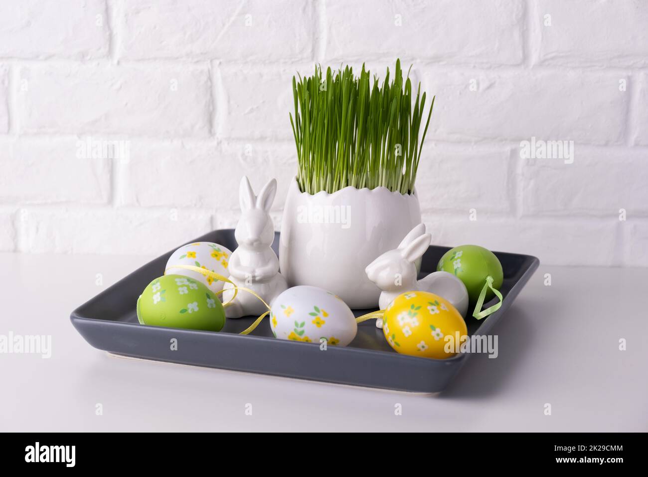 Home easter decor. Green oats, decorative rabbits and eggs Stock Photo