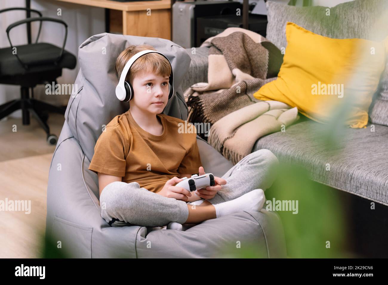 Portrait of teen boy actively and recklessly playing video game with joystick Stock Photo