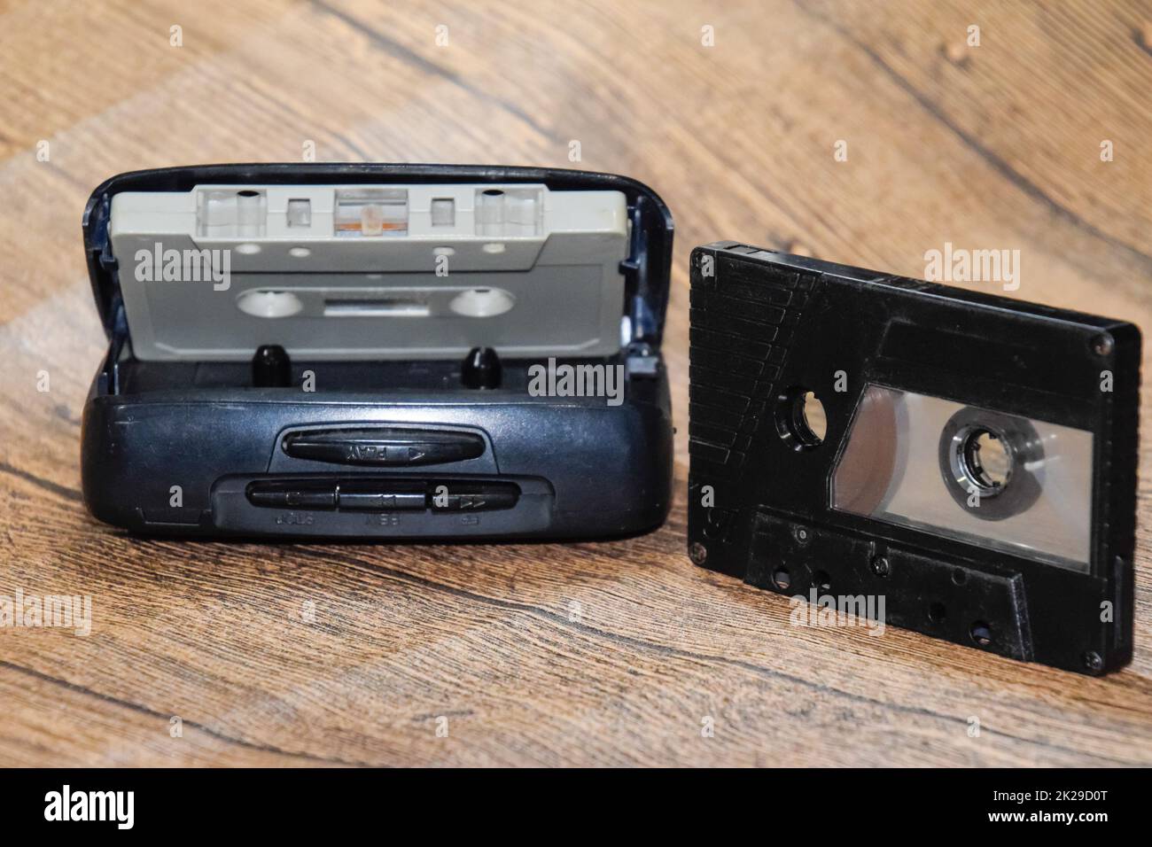 Retro audio cassettes next to a portable player to play compact
