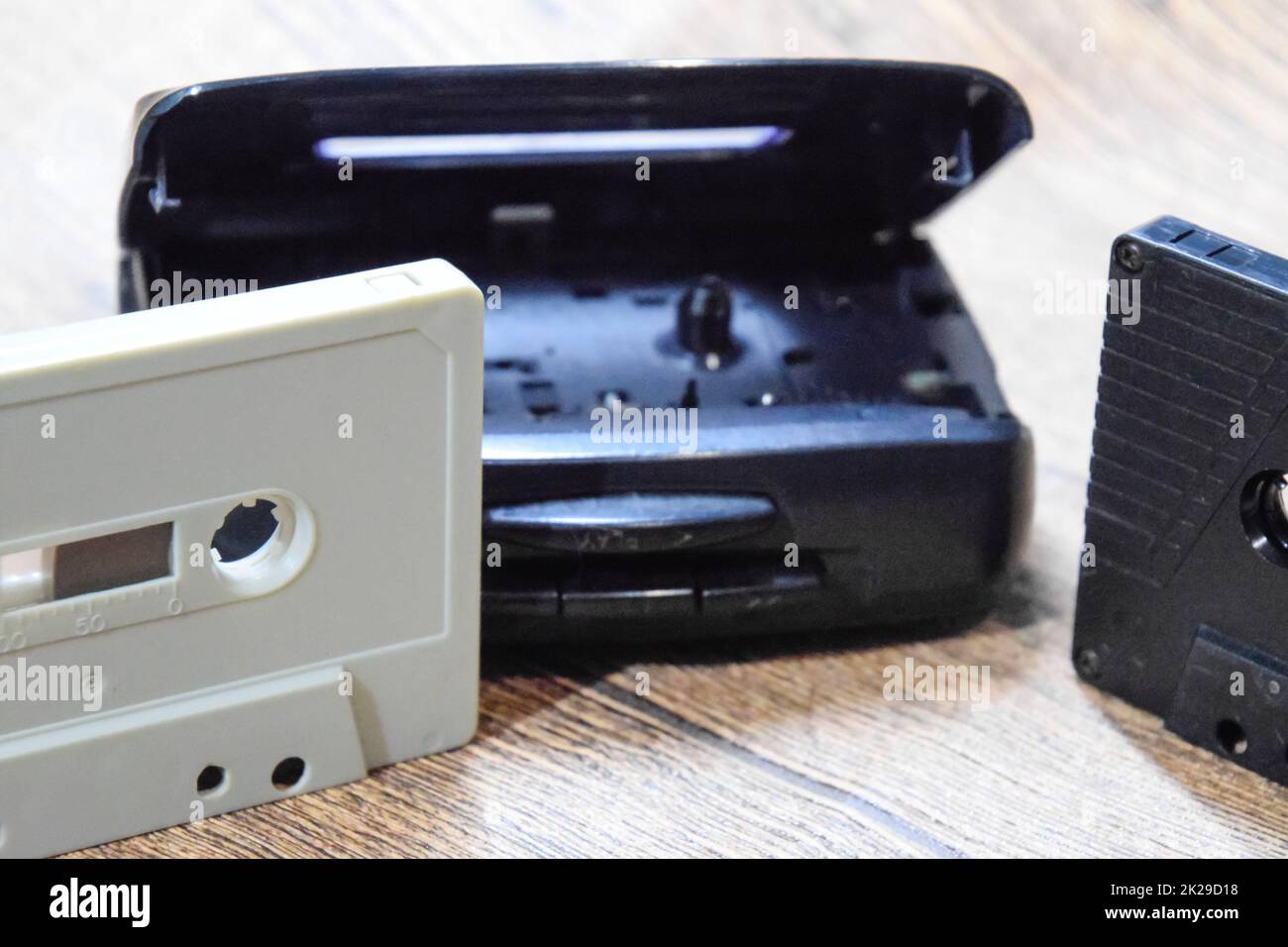 Retro audio cassettes next to a portable player to play compact