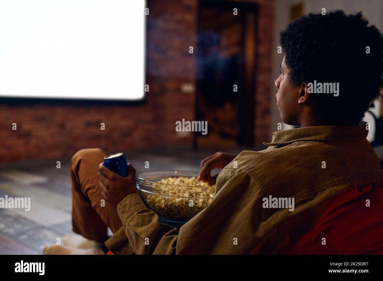 Man enjoy watching film using video projector Stock Photo