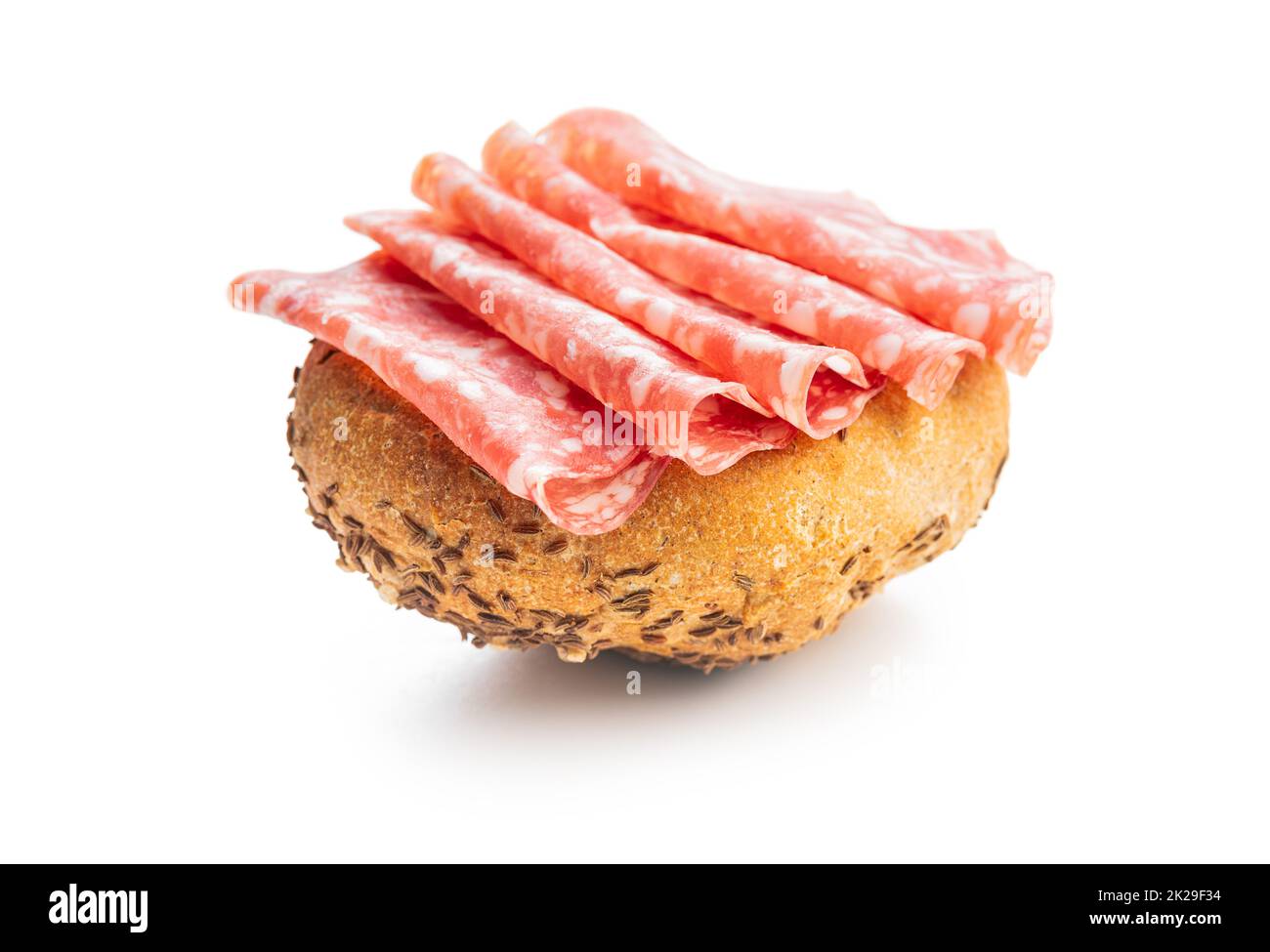 Bun with sliced salami isolated on white background. Stock Photo