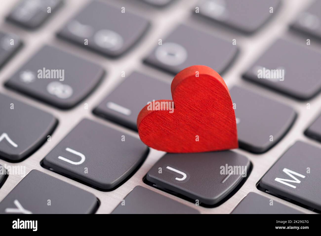 Small red heart on computer keyboard. Internet dating concept. Stock Photo