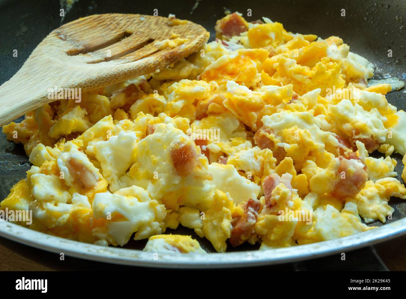 Scrambled eggs with bacon in a pan Stock Photo
