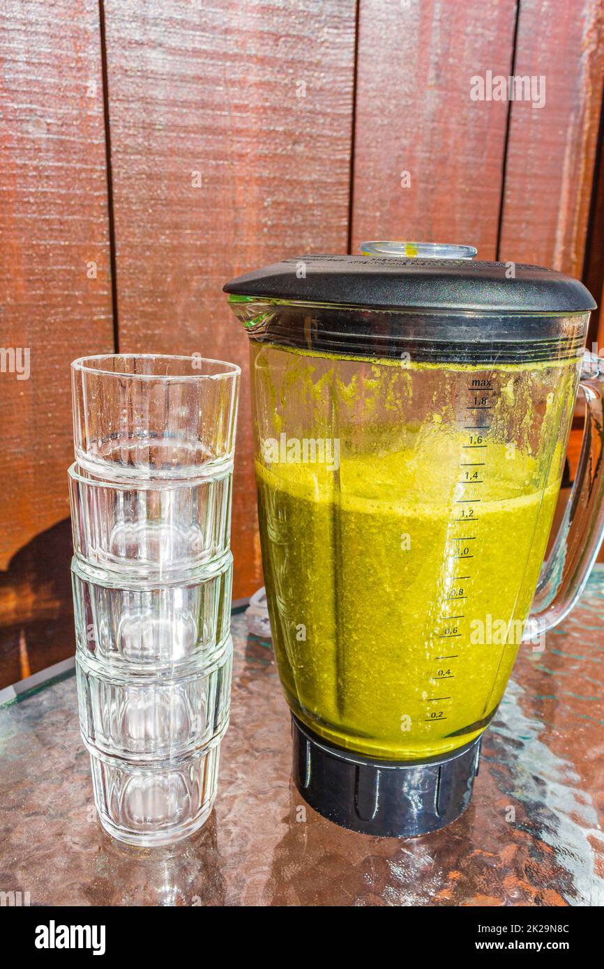 Green healthy smoothie with vegetable fruit salad greens in Blender