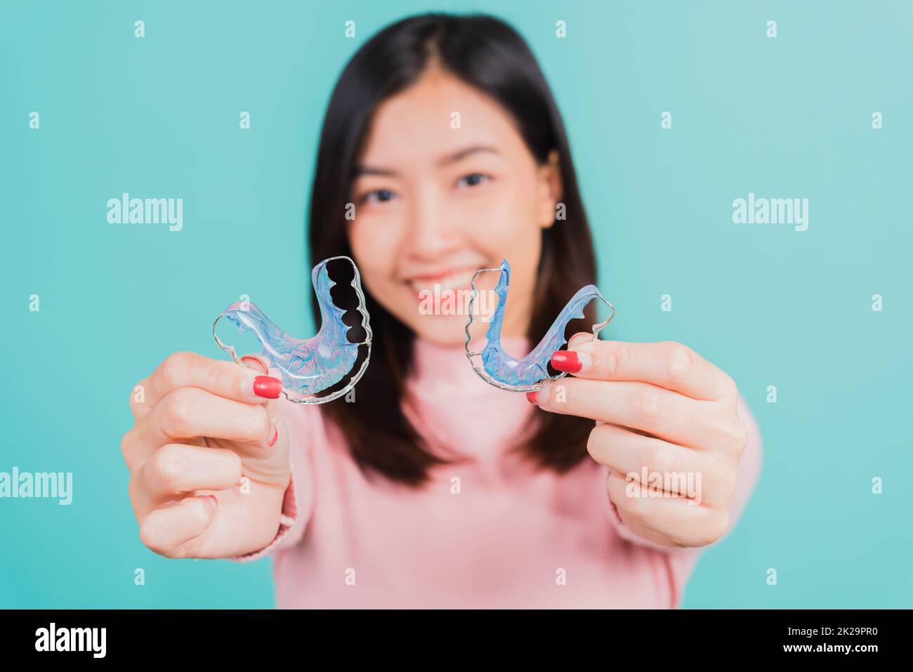 woman smiling hold silicone orthodontic retainers for teeth Stock Photo