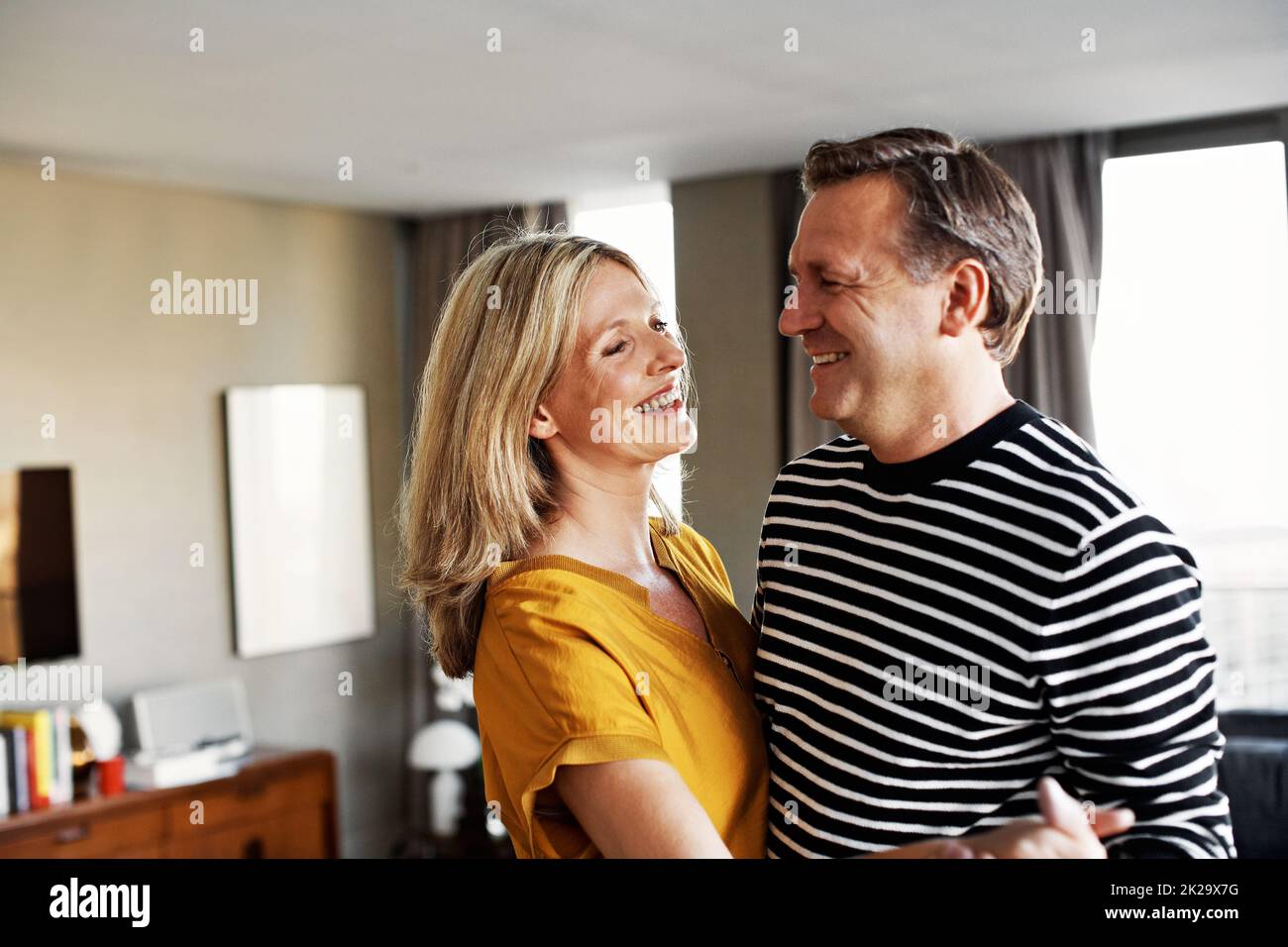 We were meant to dance together forever. Shot of a happy mature couple dancing together in their living room. Stock Photo