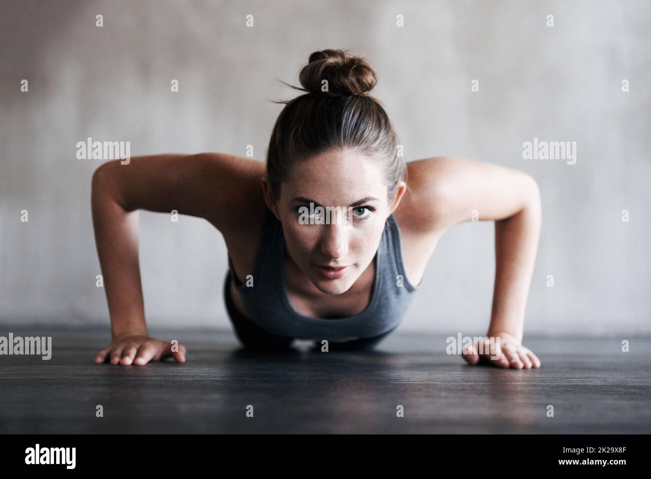 Its tough, but its worth it. Shot of a woman doing pushups at the gym. Stock Photo