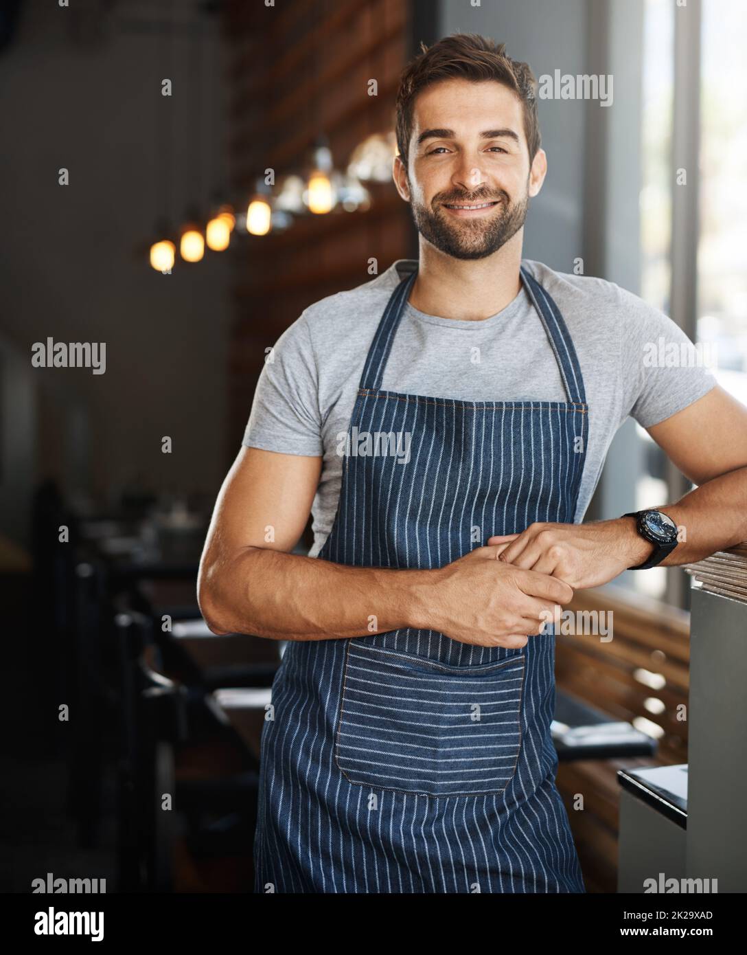 The best barista on the block. Portrait of a confident young man working in a cafe. Stock Photo