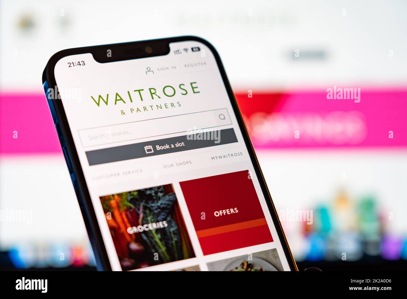 Waitrose Mobile Website with laptop website in the background Stock Photo