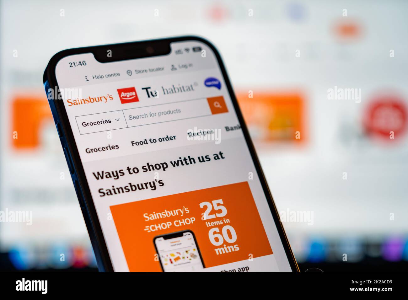Sainsburys Mobile Website with laptop website in the background Stock Photo