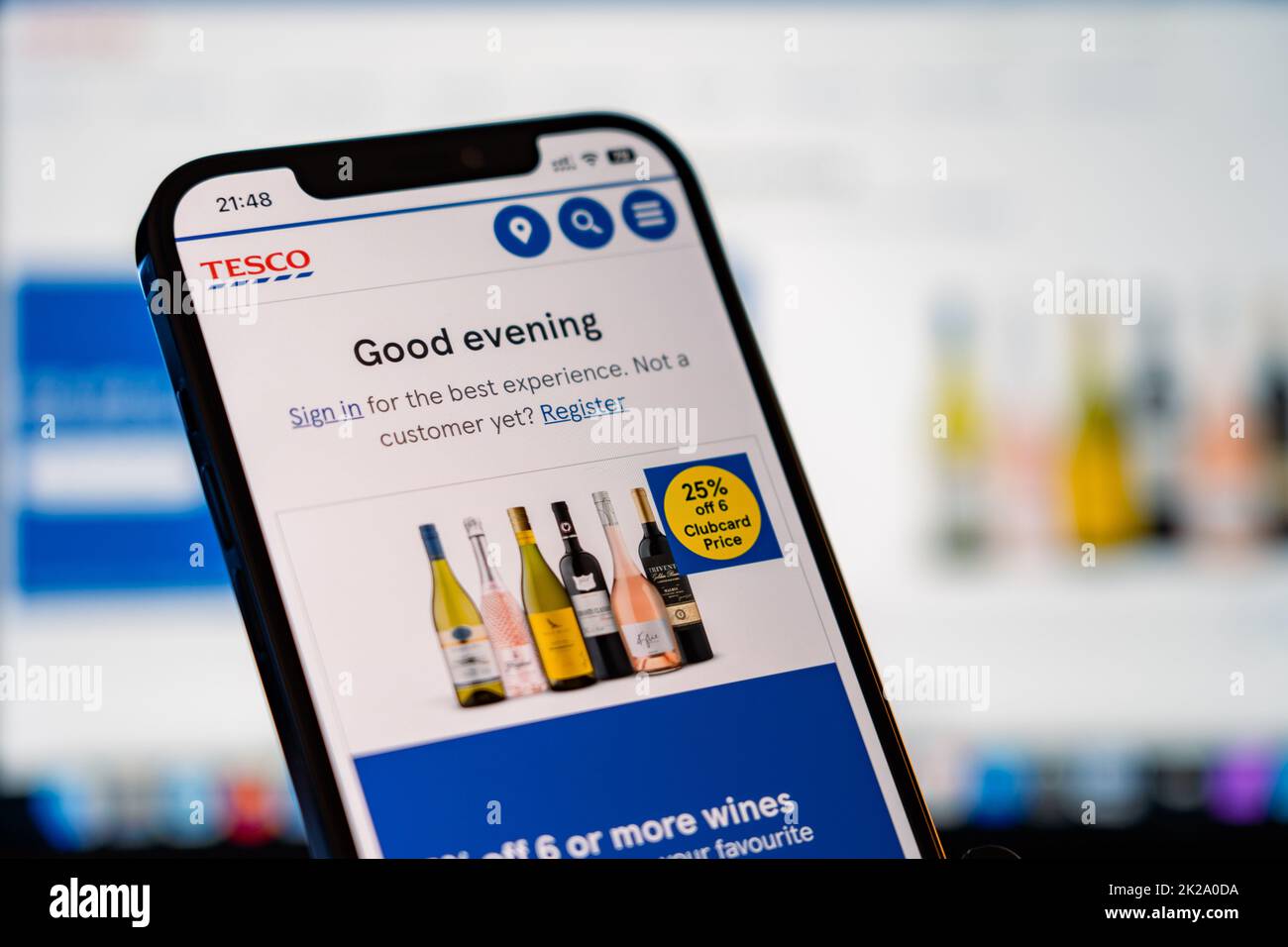 Tesco Mobile Website with laptop website in the background Stock Photo